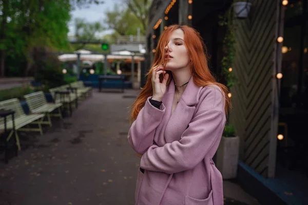Şehir parkında yürüyen güzel kızıl saçlı kadının portresi. — Stok fotoğraf