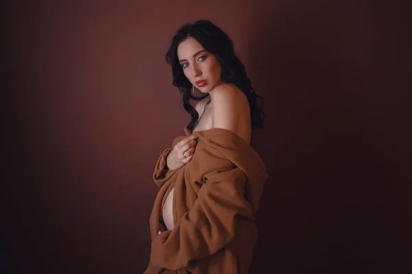 Vacker gravid ung kvinna, klädd i underkläder och tyg — Stockfoto
