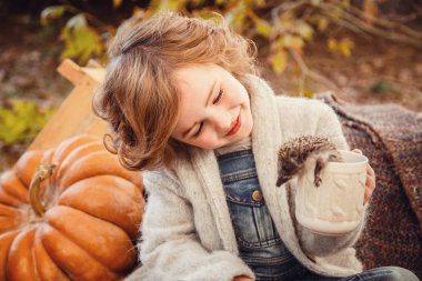 Sevimli bir kızın elinde küçük kirpi