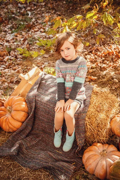 Entzückendes kleines Mädchen mit Herbstblättern im Schönheitspark — Stockfoto