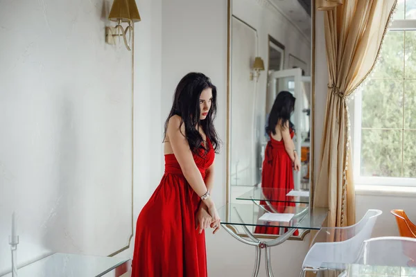 Mulher sexy bonita em vestido vermelho olhando feliz posando . — Fotografia de Stock