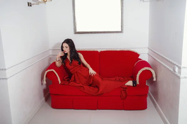 A szép lány, egy hosszú piros ruha pózol — Stock Fotó