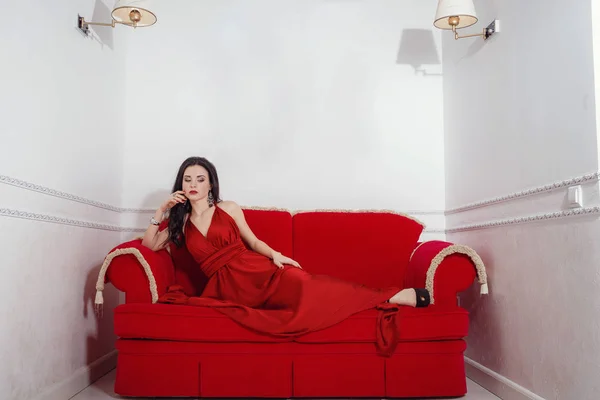 La hermosa chica en un vestido largo rojo posando —  Fotos de Stock