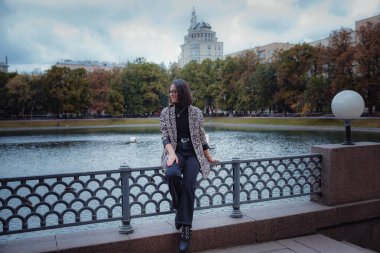 Moskova 'da güzel bir esmer kadın yürüyor. Moda bir leopar ceketiyle. Gülümsüyor ve şehirde yürüyor. Alışverişe.