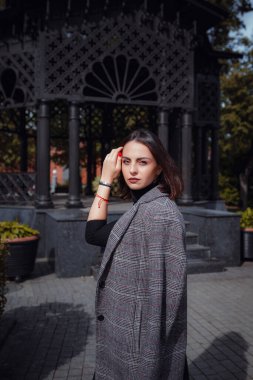 Moskova 'da güzel bir esmer kadın yürüyor. Sokakta poz veren çarpıcı trend kadının açık hava moda portresi..