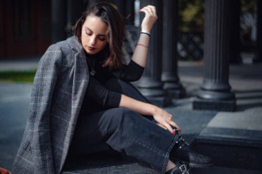 Moskova 'da güzel bir esmer kadın yürüyor. Sokakta poz veren çarpıcı trend kadının açık hava moda portresi..