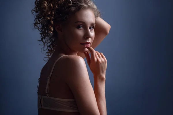 Tender portrait of a woman with curly hair in a room. Beautiful alluring young woman in sexy lingerie posing indoor. idea and concept of femininity, tenderness, spring and sexuality