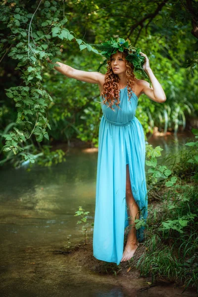 一个红头发 花环和蕨类的年轻貌美的女人在森林里庆祝仲夏的太阳日 — 图库照片