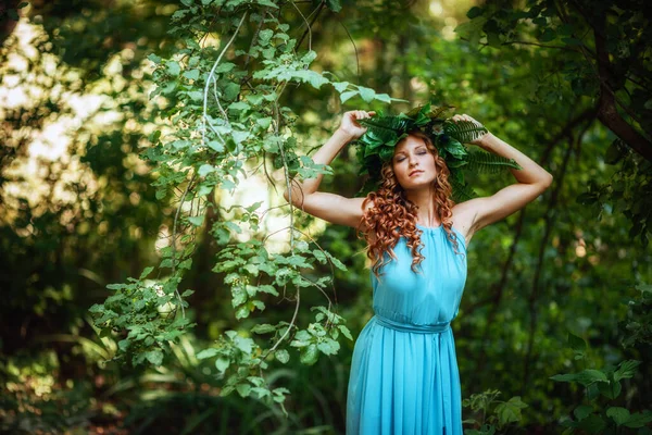 一个红头发 花环和蕨类的年轻貌美的女人在森林里庆祝仲夏的太阳日 — 图库照片