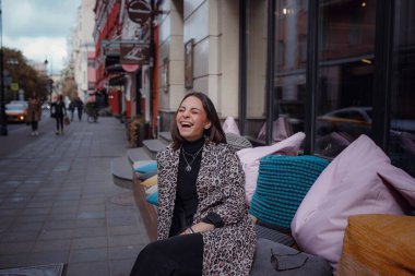 Moskova 'da güzel bir esmer kadın yürüyor. Moda bir leopar ceketiyle. Gülümsüyor ve şehirde yürüyor. Alışverişe.