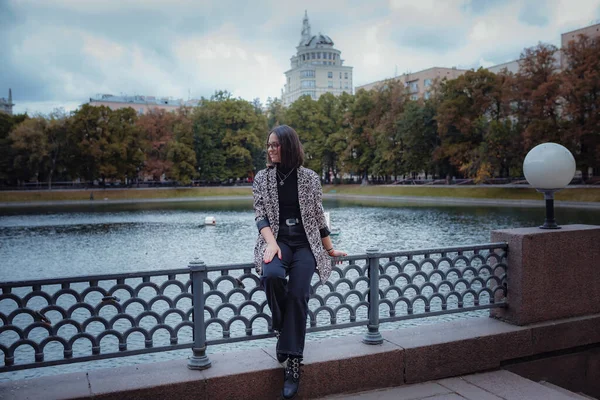 美丽的年轻黑发女子在莫斯科散步 穿着时髦的豹衣 微笑着走在城市里 去买东西 — 图库照片