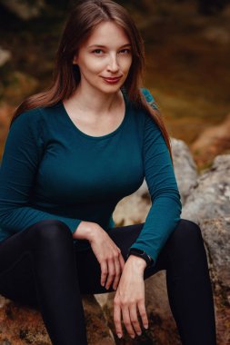 Ormanda nehir kenarında dinlenen dişi turist. Dere kenarında kadın yürüyüşü..