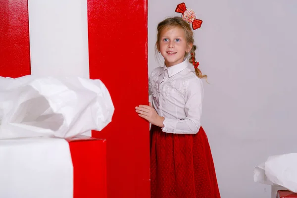Krásná Holčička Slavnostním Kostýmu Pozadí Velkých Červených Dárkových Krabic Bílém — Stock fotografie