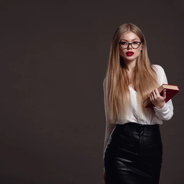 Woman teacher or business woman holding book. Female office worker wearing white shirt. Studio isolated portrait of smiling woman, business person on grey background