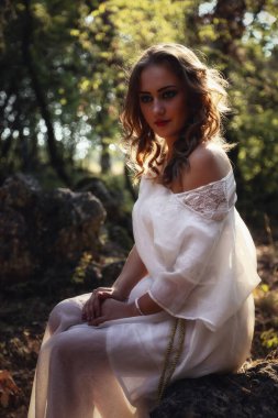 Sonbahar ormanında uzun beyaz elbiseli, gizemli gotik kadın. Karanlık fantezi yaratık