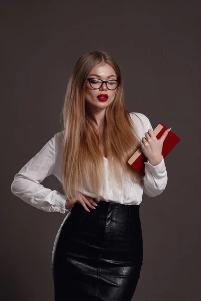 Woman teacher or business woman holding book. Female office worker wearing white shirt. Studio isolated portrait of smiling woman, business person on grey background