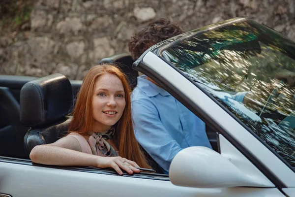 夏の道路でコンバーチブルでドライブを楽しむカップル 友達は休日に行く イタリアの休暇Serpentine道路 赤毛の女性と美しい若い男 — ストック写真
