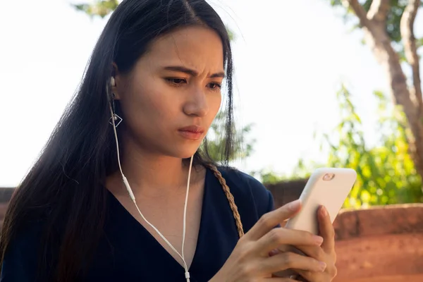 長いです髪の長いです青いドレスで彼女のスマートフォンでテキストを見ます 彼女は怒っています彼女の男の子の友人でキャンセル今日日付 — ストック写真