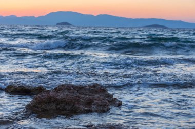 Akdeniz 'de güzel bir gün batımı vahşi ve kayalık plajları var.
