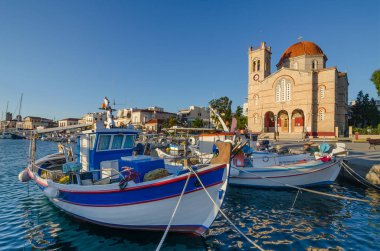 Gündoğumunda Yunanistan 'ın Saronik Körfezi' ndeki Aegina adasına demirlemiş yatları ve balıkçı tekneleri olan Aegina limanı..