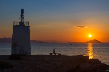 Aegina adasının eski deniz feneri, Saronic körfezi, Yunanistan, gün batımında.