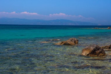 Yunanistan 'ın Saronik körfezinde Akdeniz' in berrak ve mavi sularıyla Aegina adasının vahşi kıyıları.