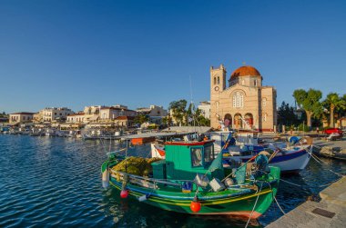 Gündoğumunda Yunanistan 'ın Saronik Körfezi' ndeki Aegina adasına demirlemiş yatları ve balıkçı tekneleri olan Aegina limanı..