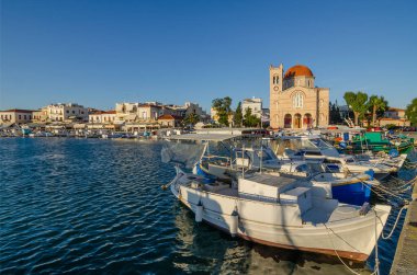 Gündoğumunda Yunanistan 'ın Saronik Körfezi' ndeki Aegina adasına demirlemiş yatları ve balıkçı tekneleri olan Aegina limanı..