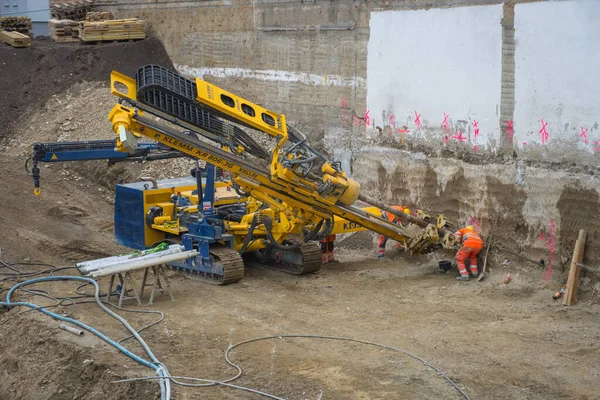 Graz / Avusturya - 09 Ekim 2019: inşaat alanında çalışan işçiler ve yerde delik açmak için kullanılan ağır iş makineleri