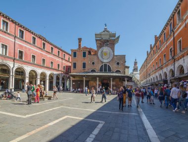Venedik, İtalya - 20 Nisan 2019: San Giacomo di Rialto Kilisesi ile güzel eski bir meydanda turist kalabalığı, güneşli bir günde.