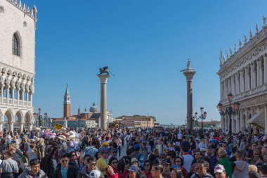 Venedik, İtalya - 20 Nisan 2019: Saint Mark Meydanı 'nda (San Marco) Doge Sarayı (Palazzo Ducale) ve arka planda San Giorgio di Maggiore kilisesi bulunan turist kalabalığı.