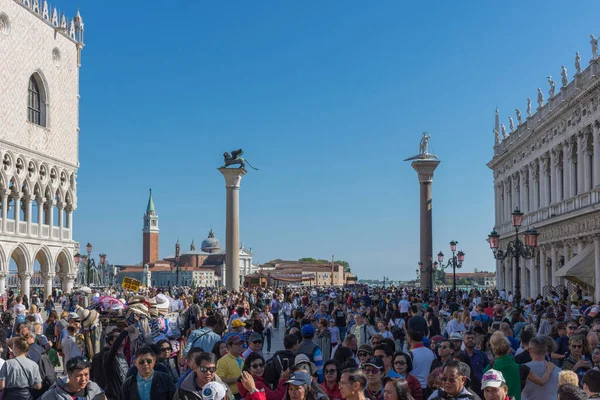 Venedik, İtalya - 20 Nisan 2019: Saint Mark Meydanı 'nda (San Marco) Doge Sarayı (Palazzo Ducale) ve arka planda San Giorgio di Maggiore kilisesi bulunan turist kalabalığı.