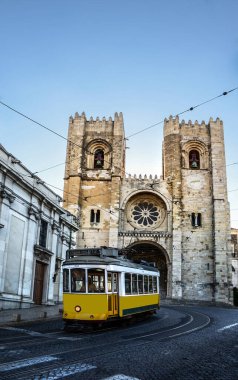 Lizbon, Portekiz 'deki Baixa' dan Alfama ilçelerine giden ana yolda bulunan Se Katedrali (Santa Maria Maior de Lisboa) önündeki klasik sarı tramvay.