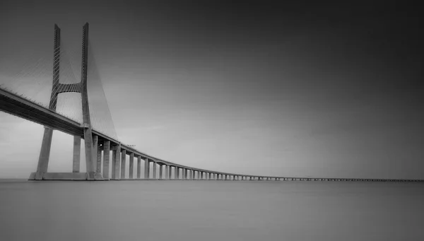 ヨーロッパ最長の橋であるヴァスコ ガマ橋は ポルトガルのリスボンにあるタガス川に架かっている 長い露出 黒と白 — ストック写真