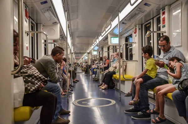Milan, İtalya - 14 Temmuz 2016: Bir metro vagonu yolcuları, trendeki yolcular varış noktasına varmak için oturuyorlar.