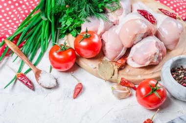 Taze maydanoz ve biber, baharatlar ile kesme tahtası üzerinde çiğ tavuk budu. Gıda arka plan. Pişirme malzemeleri. Taze et. Üstten Görünüm. Kopya alanı. 