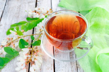 Çaydanlık ve şube akasya eski rustik ahşap masa üzerinde demlenmiş akasya çiçekleri bal ile şifa bitki çayı. 