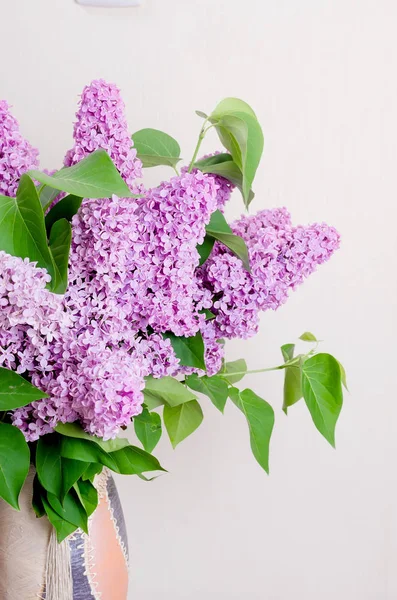 白い壁の背景の上に花瓶のライラック 素朴なスタイルの家の装飾の美しい春の花の花束 — ストック写真