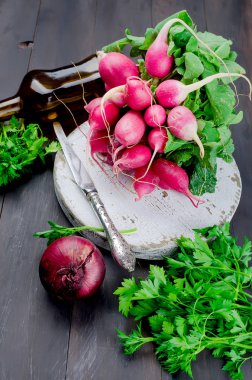 büyük kırmızı turp yaprakları ve karanlık bir eski ahşap masa, üstten görünüm salataya için malzemeler ile demet