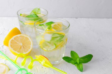 Soda ve limon cam ve malzemelerin üzerine hafif bir arka plan ile taze soğuk Mojito kokteyli