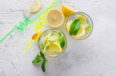 Soda ve limon cam ve malzemelerin üzerine hafif bir arka plan ile taze soğuk Mojito kokteyli