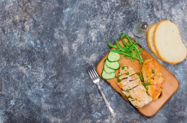 Kızarmış tavuk fileto ve sebze cutboard karanlık taş tablo öğle yemeği için. kopya spase, üstten görünüm