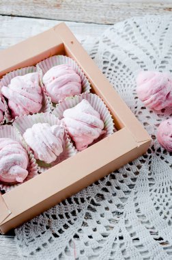 Ev yapımı üzümü pembe marshmallows - zephyr kutusunda Beyaz ahşap zemin üzerinde. Seçici odak. 