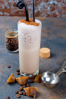 Sütlü çikolata kokteyl veya soğuk sütü ve buz ile çırpılmış kahve koyu arka plan üzerinde kopya alanı kakao serpin, 