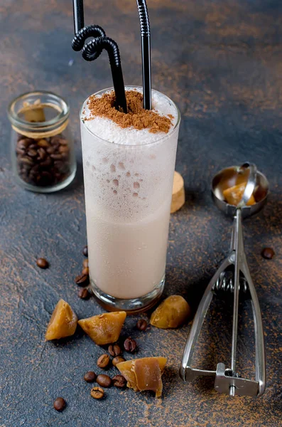Sütlü çikolata kokteyl veya soğuk sütü ve buz ile çırpılmış kahve koyu arka plan üzerinde kopya alanı kakao serpin, 