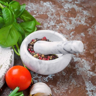 baharat, domates, yeşil soğan ve fesleğen, sarımsak, tuz ve baharat karanlık bir taş zemin üzerine taş havan topu. Üstten görünüm, kopya alanı. 