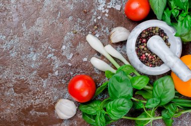 Olgun kırmızı ve sarı domates, yeşil soğan ve fesleğen, sarımsak, tuz ve baharat karanlık bir taş zemin üzerine. Üstten görünüm, kopya alanı. 
