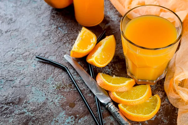 portakal suyu bir bardak ve bir şişe ve parça üstünde a beton kahverengi-mavi arka plan kopya yer Orange