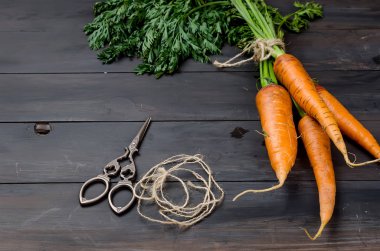 Eski koyu ahşap arka planda yeşil yapraklı taze havuçlar. Sebze. Yiyecek. 