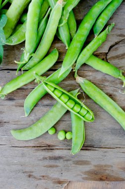 Bakla genç yeşil bezelye ve bezelye eski rustik ahşap arka plan üzerinde. Karanlık rustik tarzı.